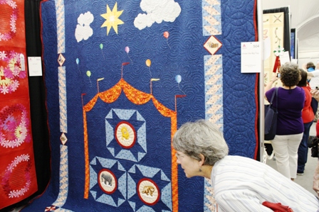 Cherry Pyron looks at quilts. Blue quilt is called "Circus"